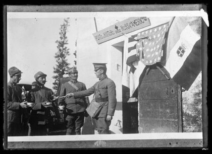 Italian soldiers lined up before the door of an improvised canteen of the ARC wear a look of appreciation w…