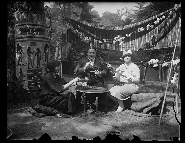 Neighborhood house garden fete. The Egyptian Minister and Mme Smay Pasha, (right) refreshing themselves wit…