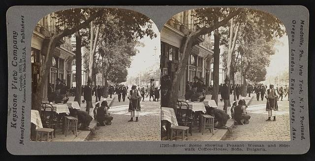 Street scene showing peasant woman and sidewalk coffee-house, Sofia, Bulgaria