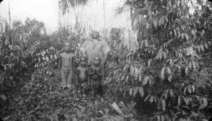 Caféière d'une famille togolaise posant au mileu de ses arbres / André Fontaine